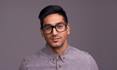 Young man, portrait and glasses in studio for eye care, vision and new frame with confidence on a...