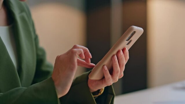 Businesswoman hands using smartphone in office closeup. Woman watching pictures