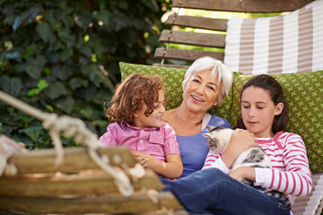 Grandmother, children and relax with cat, outdoor and sunshine with weekend break and vacation....