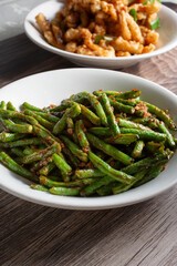 A view of a bowl of sauteed long beans in garlic sauce.
