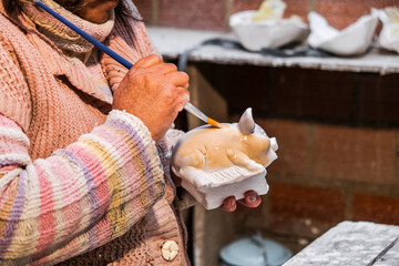 elderly latin artisan woman painting a plaster sculpture in latin america - entrepreneurship concept