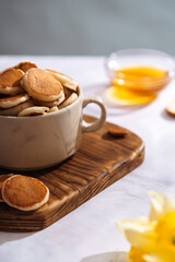 plate with small pancakes on a wooden board