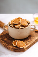 plate with small pancakes on a wooden board