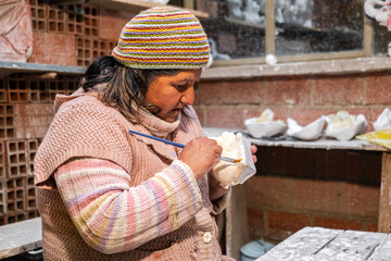 latin artisan woman at work making plaster sculptures - working concept