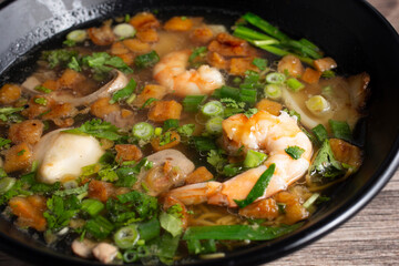 A closeup view of a combo egg noodle soup bowl.