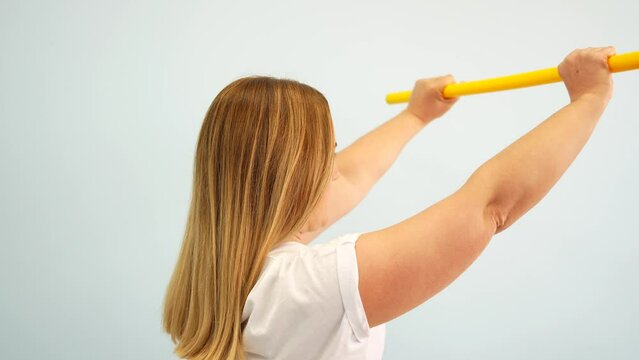 Patient performing shoulder exercises for muscle relaxation in a room with a bright white background