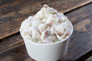 A view of a medium cup of potato salad.