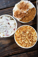 A top down view of assorted BBQ sides, featuring macaroni and cheese, potato salad and banana pudding.