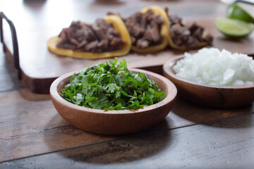 A view condiment cups of chopped cilantro and onion.