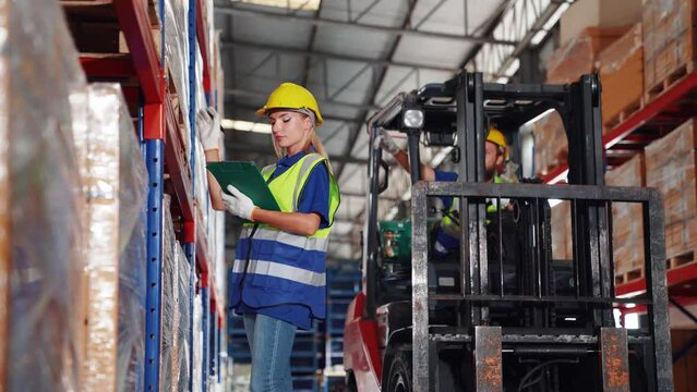 Two professional female and male warehouse checks stock workers, Forklift driver moving stock in distribution International car parts, import-export, and logistic business concepts: transportation,
