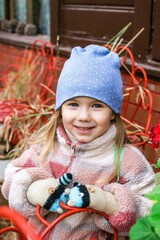 Adorable little girl with a big smile wearing a cute blue hat and colorful jacket.