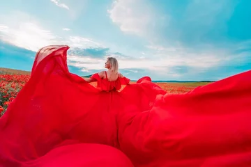 Keuken foto achterwand Woman poppy field red dress. Happy woman in a long red dress in a beautiful large poppy field. Blond stands with her back posing on a large field of red poppies © svetograph