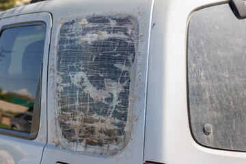 rear quarter window of silver SUV broken and covered with several layers of transparent adhesive...