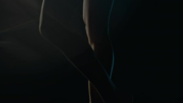 slightly moving legs, camera moves with the target, slow motion, dark, lence flair