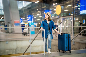 Portrait of Asian young girl with luggage and walking in international airport