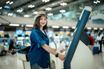 Portrait of Asian young girl using self check in machine in international airport.