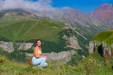 Foto op Canvas Blue Outfit Beauty: Woman Admiring Splendid Mountain View with Lush Trees and Blue Sky © Vyacheslav