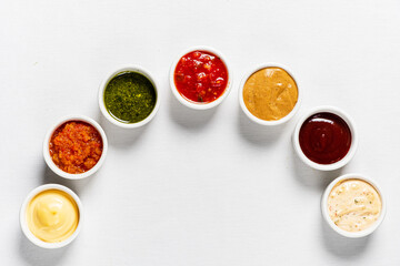 different kinds of sauces on white background