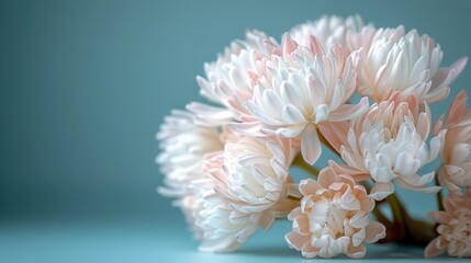  A group of pink and white blooms rest atop a light azure table beside an azure wall