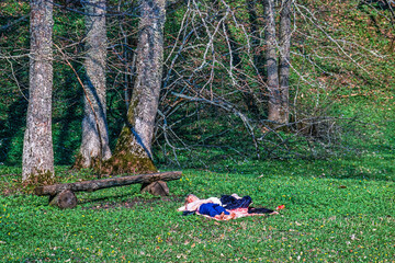 Woman lying on a blanket in the spring sun in a meadow