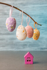 Festive Easter Scene with Hanging Eggs and Mini House - 764539373
