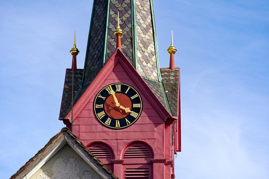 Looking up red wooden clock tower of protestant church with clock face at Swiss City of Zürich on a sunny spring afternoon. Photo taken March 20th, 2024, Zurich, Switzerland.