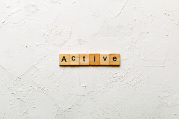 active word written on wood block. active text on table, concept