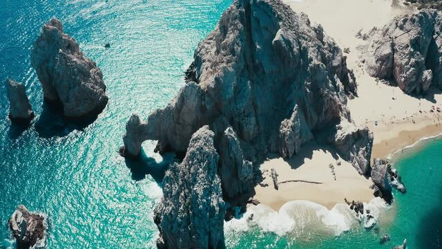 Stunning top-down drone aerial pan around shot of rock formations in a tropical paradise.  Lovers Beach Cabo San Lucas.