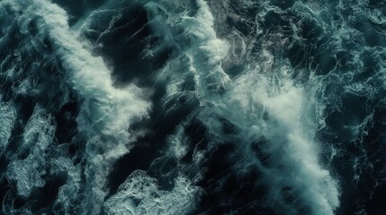 Aerial view of dark ocean waters with swirling foam patterns showcasing the powerful natural motion of the sea.