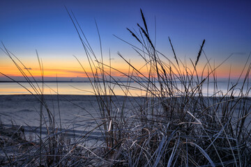 A beautiful sunset on the beach of the Sobieszewo Island at the Baltic Sea at spring. Poland - 764568907