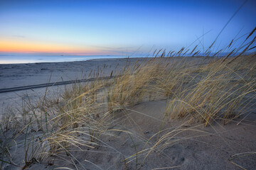 A beautiful sunset on the beach of the Sobieszewo Island at the Baltic Sea at spring. Poland - 764569128