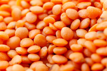 Uncooked red lentils background. Dry orange lentil grains. Top view. Close-up