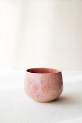 Pink ceramic coffee cup on a light background. Front view. Close-up. A place for the text. Mockup