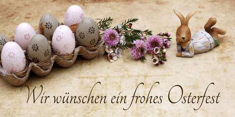 Grußkarte Frohe Ostern: Ostereier,  Blumen und Osterhase mit dem Ostergruß wir wünschen ein...