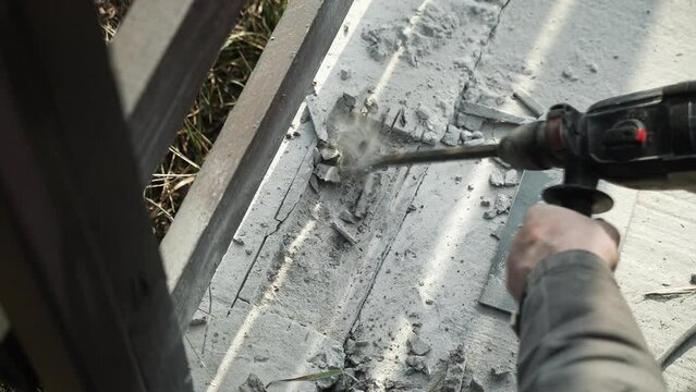 Builder Drills a hole in the wall with a Hammer Drill. Close-up of hammer drill perforator making hole