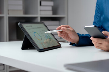 Professional analyzing financial statistics on a digital tablet with a stylus, modern business analysis.