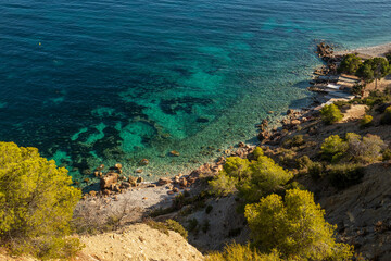 Turquoise waters and colorful trees in one of the most reserved and beautiful coves in Ibiza, Cala...