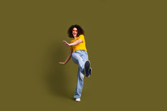 Full body size photo of millennial woman in stylish outfit chilling step toward sneakers sole brand ad isolated on khaki color background