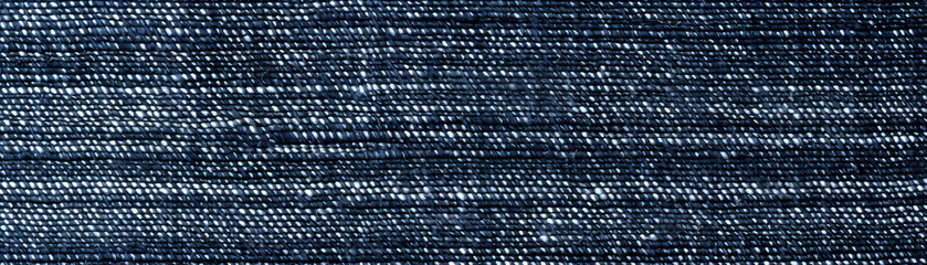 Close-up of denim fabric showing detailed texture and frayed edges - obrazy, fototapety, plakaty