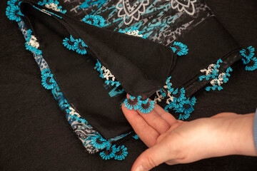 Hand-knitted scarf and headscarf samples, handmade embroidered and red head scarf, crochet and knitting thread close-up.