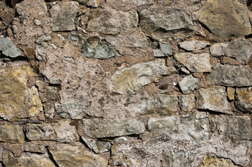 in the photo there is a close-up of an old stone wall