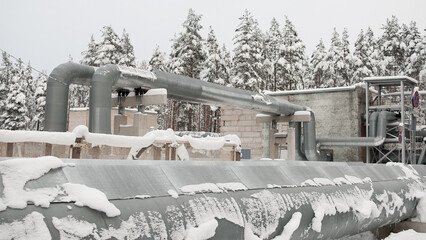 pipelines in winter against the backdrop of a snow-covered forest