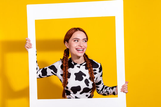 Photo of cheerful pretty lady toothy smile hold album card look empty space isolated on yellow color background