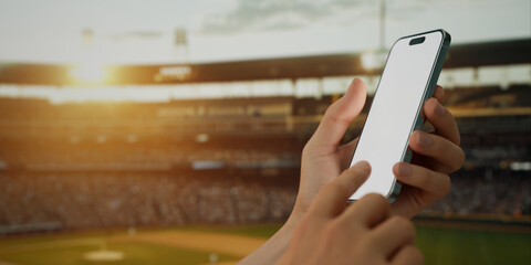 A hand holds a smartphone with a green screen at a baseball stadium - 764615733