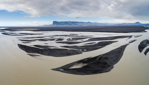 A braiding glacial river creates graphical patterns in volcanic debris on the vast glacial outwash plain Skei&eth;ar&aacute;rsandur in front of the terminus of the Vatnaj&ouml;kull glacier
