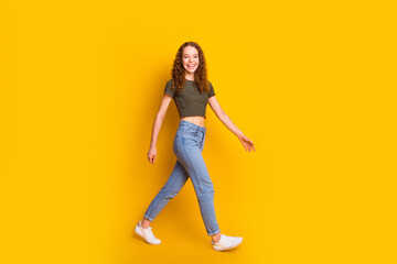 Fototapeta na wymiar Full length photo of lovely pretty positive nice girl dressed in comfortable outfit walking going isolated on yellow color background