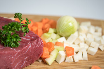 Raw beef meat on a cutting board with fresh vegetable - 764619597