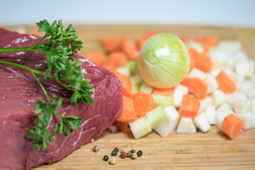 Raw beef meat on a cutting board with fresh vegetable - 764619761
