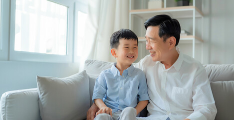 Portrait of father and son. Asian middle age male with boy, smiling and happy sitting indoor. Father's Day concept.