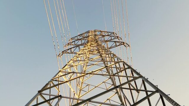 Low angle cinematic shot on the structure of a high voltage power pylon viewed from below